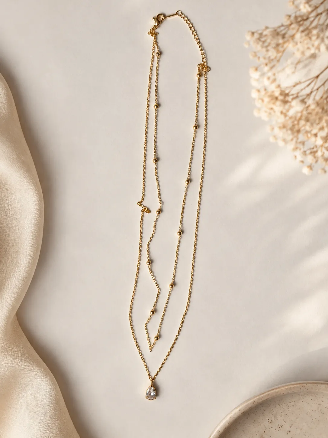 Noor Crystal Layered Necklace, a gold-toned layered necklace with a sparkling teardrop pendant